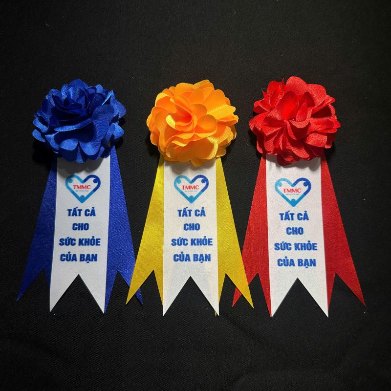 Hoa cài áo đón khách in theo yêu cầu